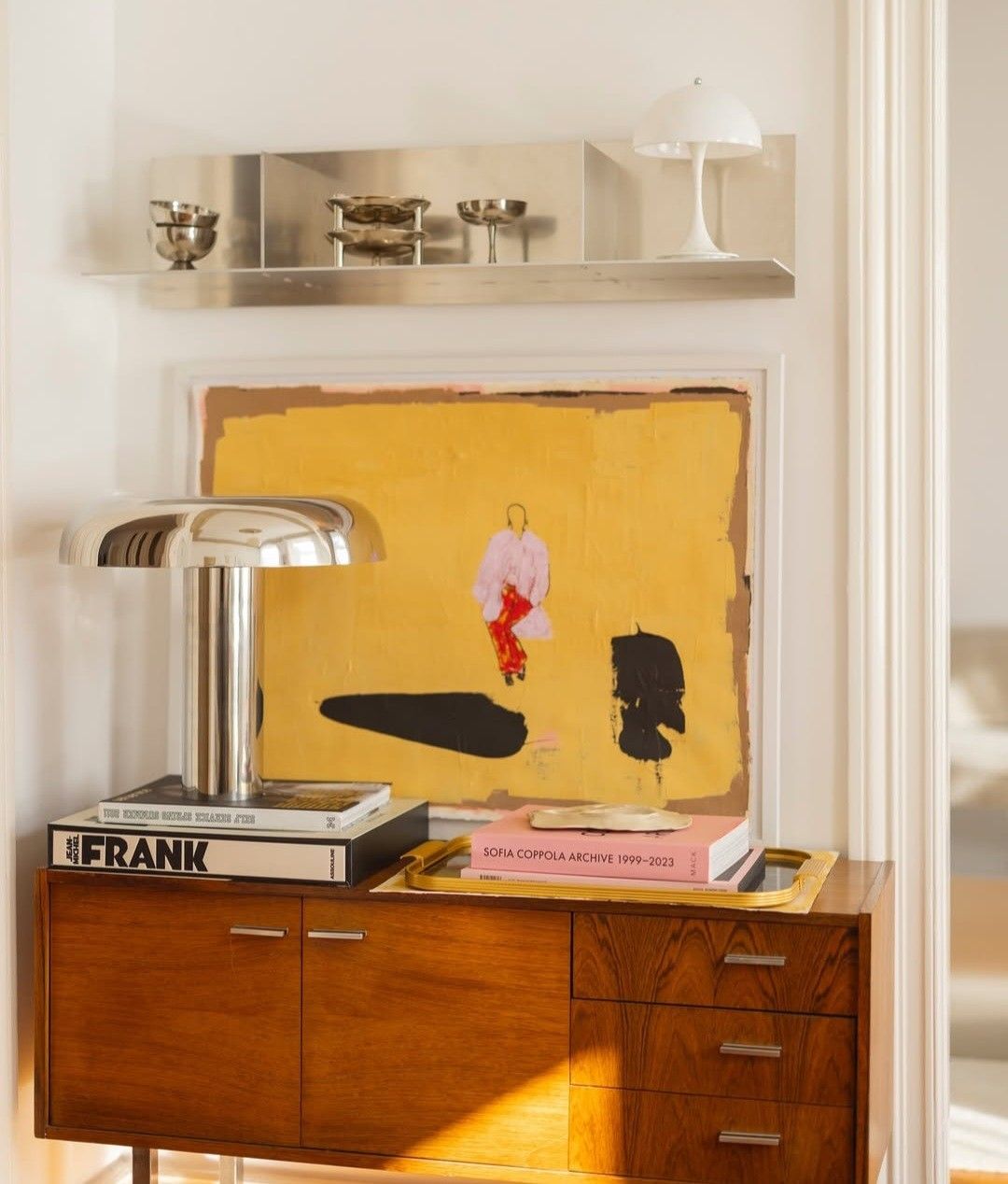 Credenza en noyer avec lampe chrome, tableau abstrait jaune et livres d'art