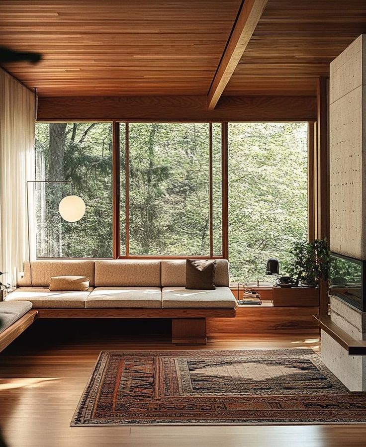 Salon japonais avec banquette encastree, baies vitrees sur foret et tapis persan